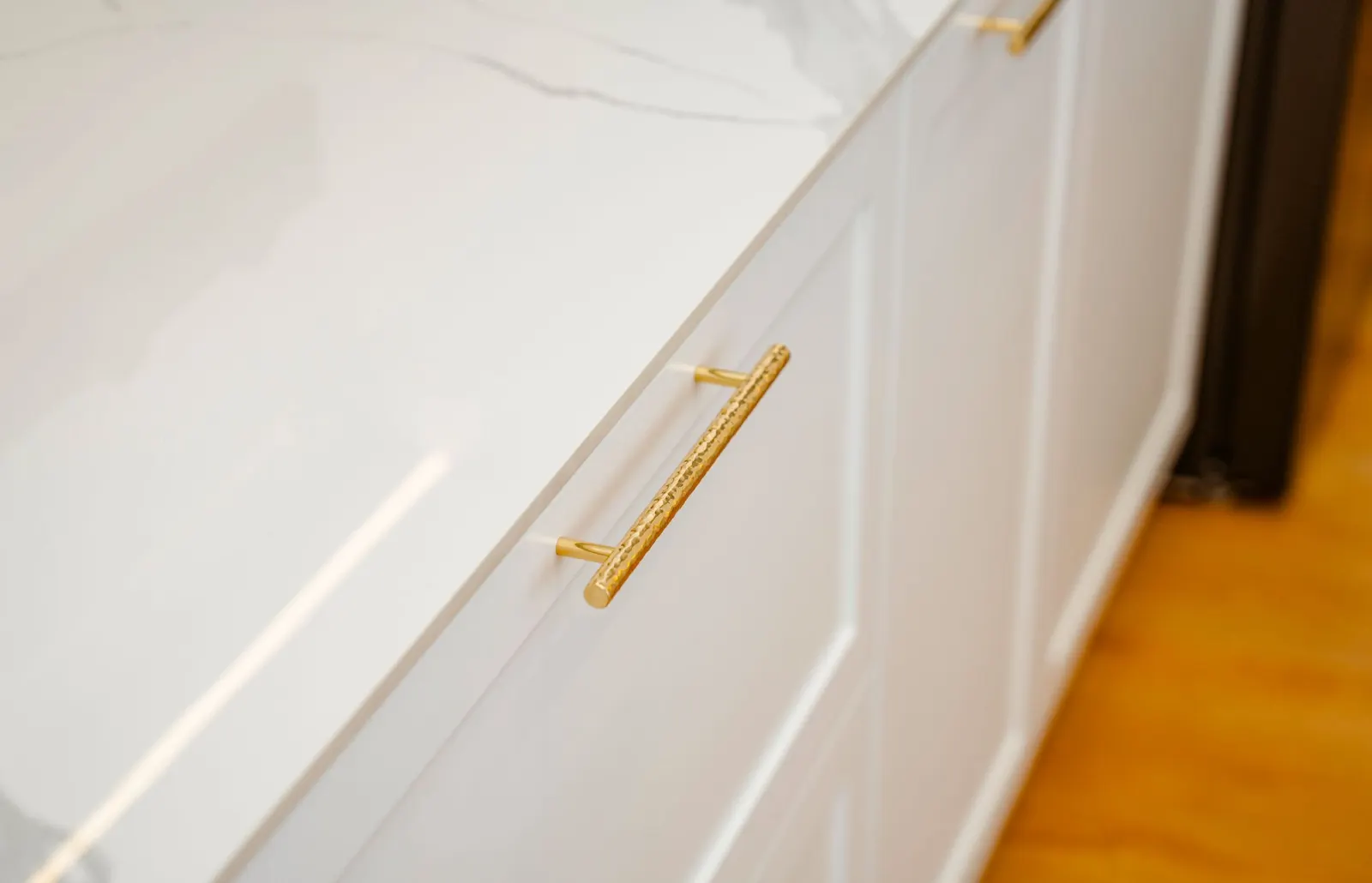 Close-up of white shaker cabinet doors with brass handles