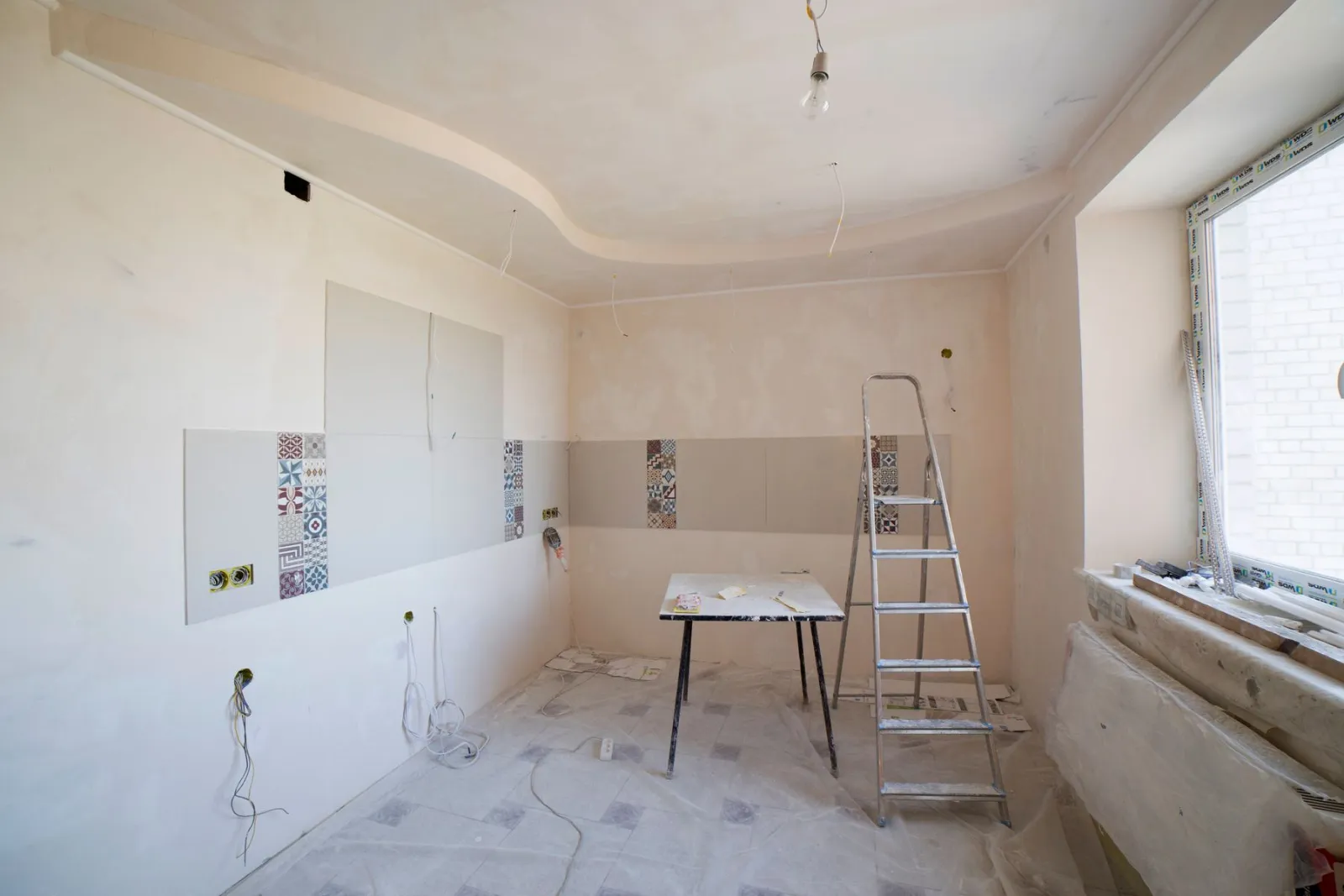 Kitchen interior during finishing work with ladder and materials